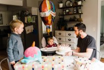 Un an fête son anniversaire en famille à table avec gâteau — Photo de stock