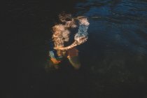 Junge trägt einen Stein unter Wasser — Stockfoto