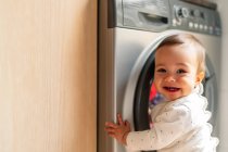 Дівчинка сміється з пральною машиною — стокове фото