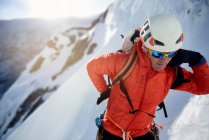 Ледяной альпинист чинит свою стаю перед скалолазанием — стоковое фото