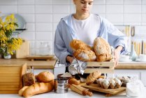 Молодая девушка держит хлеб на кухне — стоковое фото