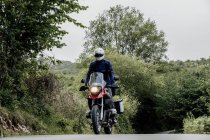 Man riding a motorcycle in forest — Stock Photo