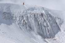 Чоловік катається на сноуборді на краю засніженої гори під час відпустки — стокове фото