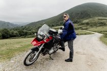 Homem com motocicleta no campo — Fotografia de Stock