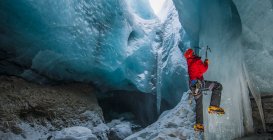 Mann klettert Eiszapfen in Gletscherhöhle in Island — Stockfoto