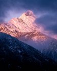 Malerischer Blick auf den schneebedeckten Berg gegen wolkenverhangenen Himmel bei Sonnenuntergang — Stockfoto
