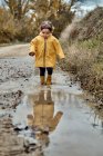 A 2 year old girl playing with a mud puddle — Stock Photo