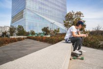 Женщина в кепке сидит со скейтбордом — стоковое фото