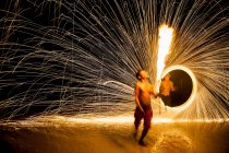 Огненная танцовщица выступает на пляже в Рэйли — стоковое фото