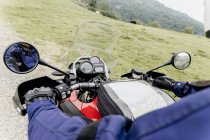Un hombre está conduciendo la moto en las montañas - foto de stock