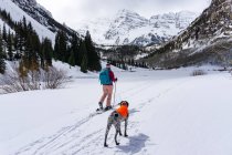 Young woman hiking with Pointer dog during winter — Stock Photo