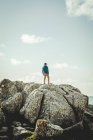 Jeune homme debout sur la falaise — Photo de stock