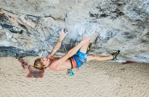 Young man climbing overhanging rock face at Tonsai beach — Stock Photo