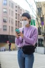 Giovane donna con cellulare in città — Foto stock