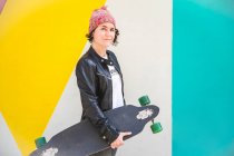 Женщина со скейтбордом в руках — стоковое фото
