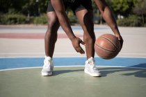 Cropped African American man doing freestyle dribbling on court during training — Stock Photo