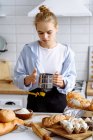 Girl makes bread dough in a kitchen — Stock Photo
