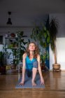 Woman doing yoga at home houseplants in background — Stock Photo