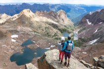 Vista posteriore di coppia guardando la vista mentre in piedi sulla montagna — Foto stock