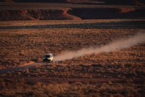 Veículo off-road em movimento na estrada de terra no deserto — Fotografia de Stock