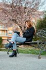 Приваблива молода жінка дивиться на свій планшет у парку — стокове фото