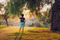 Молодий хлопчик стоїть біля дерева — стокове фото