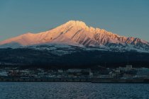 Vista panorâmica da montanha coberta de neve contra o céu limpo durante o pôr do sol — Fotografia de Stock