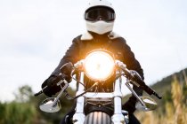 Low angle view of a motorcycle standing on the road with its owner alone — Fotografia de Stock