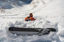 Mann im Urlaub beim Snowboarden am Berg im Schnee — Stockfoto