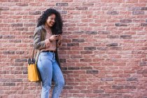 Une heureuse jeune femme afro-américaine parlant avec un téléphone portable en ville — Photo de stock
