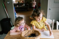 Meninas gêmeas da criança passar o tempo juntos na cozinha enquanto coloração — Fotografia de Stock