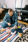 Un giovane padre felice e la sua bambina giocano insieme sul pavimento — Foto stock
