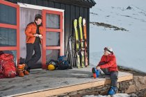 Casal se preparando para excursão de esqui na casa de esqui na Islândia — Fotografia de Stock