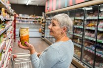 Caucasian adult woman with vegetable pot in supermarket — Stock Photo