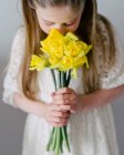 Belle petite fille avec bouquet de tulipes jaunes — Photo de stock
