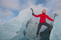 Woman climbing iceberg on the south coast of Iceland using ice pick — Stock Photo