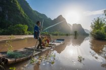Pescatore su zattera tradizionale sul fiume Yulong vicino a Yangshuo — Foto stock