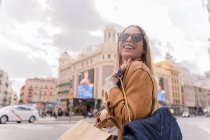 Schöne Frau hält Einkaufstüten und lächelt — Stockfoto