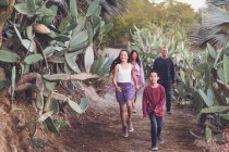 Сім'я змішаної раси з чотирма ходячи по стежці кактусів . — стокове фото