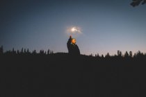 Menino iluminado por Sparkler fica na floresta no crepúsculo — Fotografia de Stock