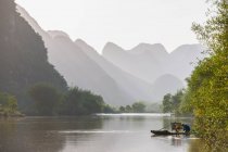 Fisherman on traditional raft on the Yulong river close to Yangshuo — Stock Photo
