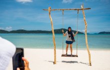 Giovane donna con uno zaino sulla spiaggia — Foto stock