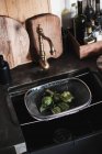 Carciofi freschi verdure e rubinetto su un tavolo di legno — Foto stock