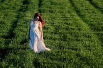 Молода жінка позує в зеленому полі — стокове фото