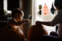 Двое детей тыква резьба на Хэллоуин в их доме — стоковое фото