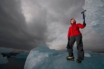 Mulher escalando iceberg na costa sul da Islândia usando picador de gelo — Fotografia de Stock