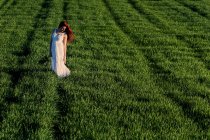 Молода жінка позує в зеленому полі — стокове фото