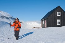 Mulher partida para uma caminhada a partir de casa de esqui na Islândia — Fotografia de Stock