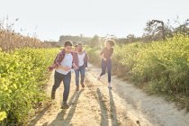 Счастливая семья бегает по деревне весной — стоковое фото