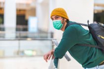 Homem espanhol moderno com máscara de proteção verde no shopping — Fotografia de Stock